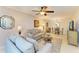 Comfortable living room with beige sofas, glass coffee table, fan and view to dining area at 5631 Midnight Pass Rd # 1007, Sarasota, FL 34242