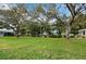 Large green backyard space with mature trees and landscaping at 565 Sutton Place, Longboat Key, FL 34228