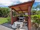 Barbecue and stone seating situated within tropical foliage, perfect for outdoor cooking and dining at 565 Sutton Place, Longboat Key, FL 34228