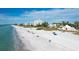 Expansive beach view showcases the coastline with modern condominium buildings and crystal clear waters at 565 Sutton Place, Longboat Key, FL 34228