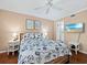 Comfortable bedroom featuring a queen bed with nautical-themed bedding and beach artwork on the wall at 565 Sutton Place, Longboat Key, FL 34228