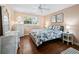 Cozy bedroom featuring a bed with nautical themed bedding, wooden floors, and a white wicker side table at 565 Sutton Place, Longboat Key, FL 34228