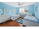 Charming blue bedroom featuring two twin beds, bright natural light, and coastal decor at 565 Sutton Place, Longboat Key, FL 34228