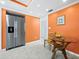 Cozy breakfast nook featuring an orange wall, a glass table, and a stainless steel refrigerator at 565 Sutton Place, Longboat Key, FL 34228