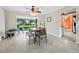 Bright dining room featuring a ceiling fan, tile flooring, and a large window overlooking the landscaped yard at 565 Sutton Place, Longboat Key, FL 34228