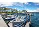 View of several boats docked along the waterfront of the property and a building with many floors at 565 Sutton Place, Longboat Key, FL 34228