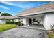Inviting covered carport features tropical landscaping, fresh paint, and ample space at 565 Sutton Place, Longboat Key, FL 34228