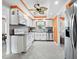 Clean, well-lit kitchen with white cabinets, stainless steel appliances, and an orange accent trim at 565 Sutton Place, Longboat Key, FL 34228