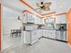 Clean, well-lit kitchen with white cabinets, stainless steel appliances, and a dining area nearby at 565 Sutton Place, Longboat Key, FL 34228