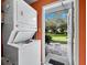 Laundry room with a stacked washer and dryer and access to the outdoors with a view of landscaping at 565 Sutton Place, Longboat Key, FL 34228