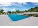 Exterior pool surrounded by lush landscaping and serene seating, a great community hangout spot at 565 Sutton Place, Longboat Key, FL 34228