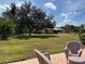 Expansive backyard with lush grass, mature trees, and a glimpse of the pool area at 5657 Westwind Ln, Sarasota, FL 34231