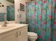 Well-lit bathroom features a floral shower curtain, vanity, and toilet at 5657 Westwind Ln, Sarasota, FL 34231