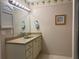 Bathroom with a vanity sink, mirror with Hollywood lights, and decorative wallpaper at 5657 Westwind Ln, Sarasota, FL 34231