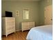 Comfortable bedroom with charming white wicker dressers and a flatscreen TV at 5657 Westwind Ln, Sarasota, FL 34231