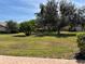 Well-maintained front yard with mature trees, lush green grass, and decorative landscaping at 5657 Westwind Ln, Sarasota, FL 34231