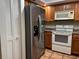 Well-equipped kitchen featuring stainless steel refrigerator, white appliances, and ample cabinet space at 5657 Westwind Ln, Sarasota, FL 34231