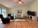 Spacious living room featuring tile flooring, a comfortable sofa, and a modern entertainment center at 5657 Westwind Ln, Sarasota, FL 34231