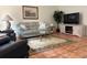 Cozy living room featuring a comfortable sofa, modern television, neutral decor, and tile floors at 5657 Westwind Ln, Sarasota, FL 34231