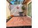 Enclosed brick-paved patio features a sunny sunburst wall hanging, lush plants, and a small table with chairs at 5657 Westwind Ln, Sarasota, FL 34231