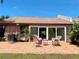 Inviting patio with brick pavers, outdoor seating, and sliding glass doors to the home's interior at 5657 Westwind Ln, Sarasota, FL 34231