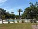 Community pool area featuring a fenced-in pool, lounge chairs, and lush tropical landscaping at 5657 Westwind Ln, Sarasota, FL 34231