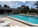 Community pool featuring a large swimming area, lounge chairs, and a covered shelter at 5657 Westwind Ln, Sarasota, FL 34231