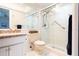 Updated bathroom featuring a walk-in shower with glass doors, neutral tile and grab bars at 600 Manatee Ave # 111, Holmes Beach, FL 34217