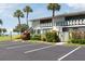 Condo exterior showcasing guest parking, lush landscaping, and access to the upper units at 600 Manatee Ave # 111, Holmes Beach, FL 34217