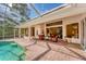 Relaxing pool patio with seating, a screened enclosure, and access to the home's interior at 6620 Saint James Xing, University Park, FL 34201