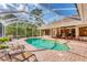 Beautiful swimming pool surrounded by a screened lanai, brick pavers, and plenty of room for lounging at 6620 Saint James Xing, University Park, FL 34201