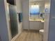Bathroom with a walk-in shower, light wood flooring, white cabinets, toilet and a sink at 6882 Holo Ct, North Port, FL 34287