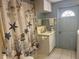 A serene bathroom with a seashell-themed shower curtain and a sink with ample counter space at 6882 Holo Ct, North Port, FL 34287