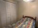 Bedroom featuring a closet, bed with patterned comforter, and wood headboard at 6882 Holo Ct, North Port, FL 34287
