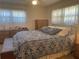 Inviting bedroom with soft lighting, patterned bedding, and matching dresser and nightstands at 6882 Holo Ct, North Port, FL 34287