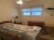 Comfortable bedroom with window, ceiling fan, dresser, night stand, bed with comforter at 6882 Holo Ct, North Port, FL 34287
