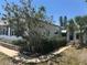 Charming single-story home with well-maintained landscaping, a brick wall, palm tree, and a inviting entrance at 6882 Holo Ct, North Port, FL 34287