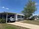 Charming single-story home with a covered parking and well-maintained lawn under a clear blue sky at 6882 Holo Ct, North Port, FL 34287