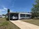 Charming single-story home with a covered parking area and well-maintained landscaping at 6882 Holo Ct, North Port, FL 34287