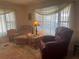 Comfortable living room with matching armchairs and windows providing ample natural light at 6882 Holo Ct, North Port, FL 34287