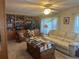 Cozy living room with a built-in bookcase, plush sofa, and a decorative coffee table with book collection at 6882 Holo Ct, North Port, FL 34287