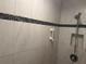 Close up of shower with accessible grab bars and tile featuring an attractive decorative stripe at 6882 Holo Ct, North Port, FL 34287