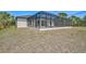 Backyard view showcasing the screened-in pool, spacious yard, and modern house design at 7116 Quarry St, Englewood, FL 34224