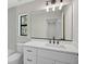 Well-lit bathroom features a modern vanity, drawers, and a large mirror with a decorative light fixture at 7116 Quarry St, Englewood, FL 34224