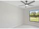 Bright, white bedroom with ceiling fan and natural light from a black-trimmed window at 7116 Quarry St, Englewood, FL 34224