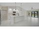 Open-concept kitchen with a center island, white cabinets, stainless steel appliances, and pendant lighting at 7116 Quarry St, Englewood, FL 34224
