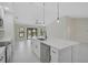 Open-concept kitchen featuring an island, stainless steel dishwasher, and white cabinetry at 7116 Quarry St, Englewood, FL 34224