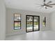 Bright main bedroom with a ceiling fan, large windows, and access to a screened lanai at 7116 Quarry St, Englewood, FL 34224
