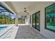 Covered patio with view of screened-in pool, ceiling fan and glass doors at 7116 Quarry St, Englewood, FL 34224