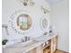 Elegant bathroom with double sinks, stone counters, wood cabinets, and decorative mirrors at 723 S Blvd Of The Presidents, Sarasota, FL 34236